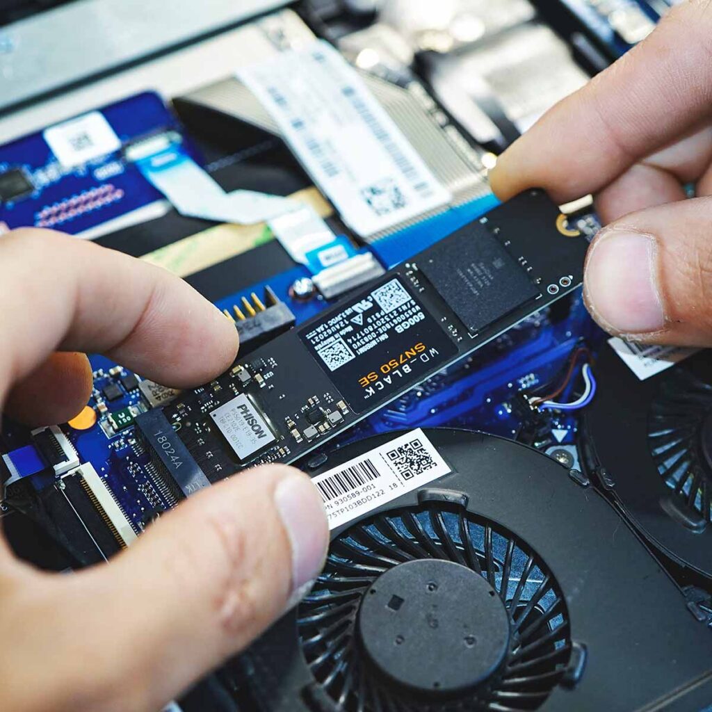 Person installing WD-Black M.2 NVME ssd in a laptop